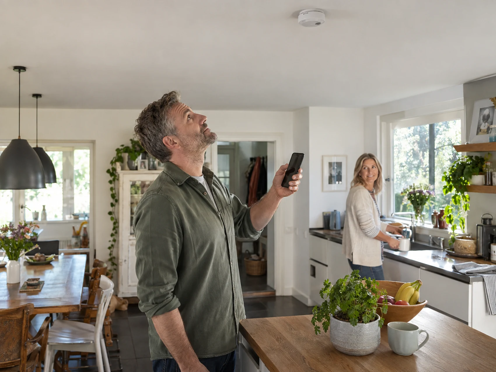 Homeowner checking a residential smoke alarm